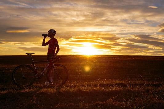 cyclist having a drink at sunset