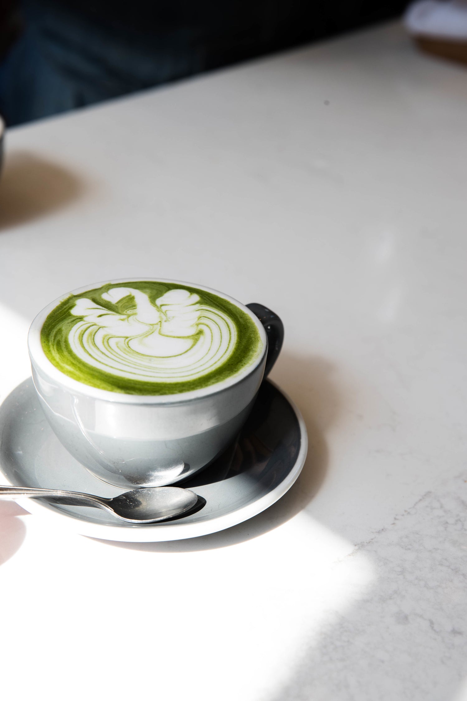 Matcha latte with latte art on a white table